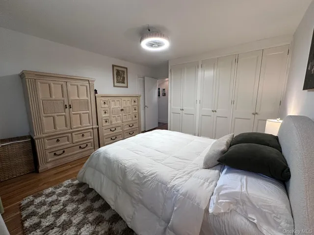 a bedroom with a bed and a refrigerator