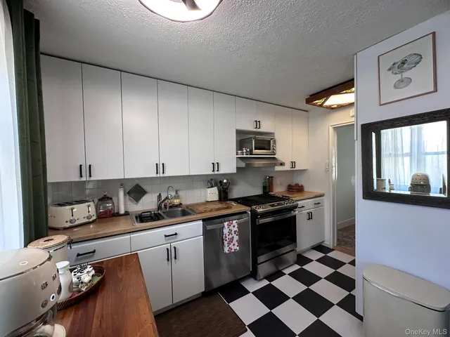 a kitchen with stainless steel appliances granite countertop a sink a stove a microwave and cabinets