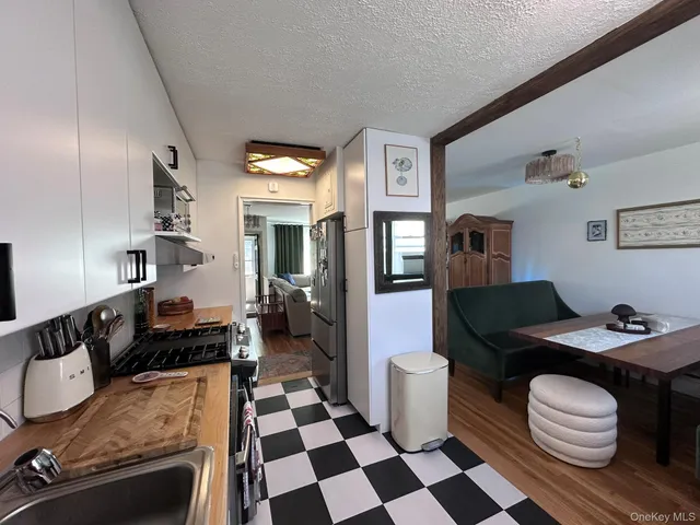 a living room with a black white checkered floor with couches chair and a coffee table