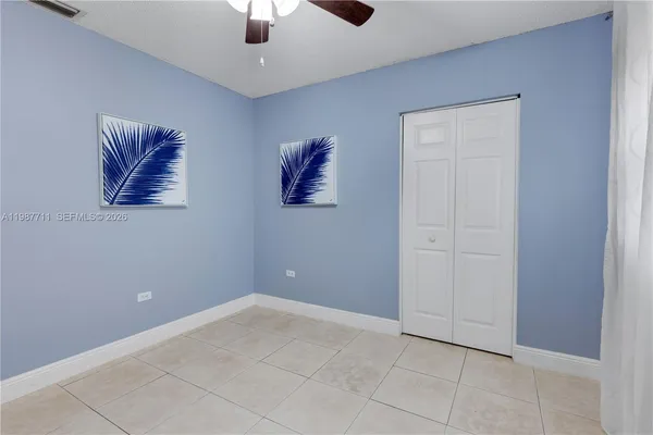 an empty room with windows and fan