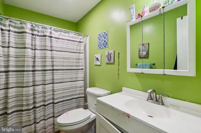 a bathroom with a sink mirror vanity and toilet