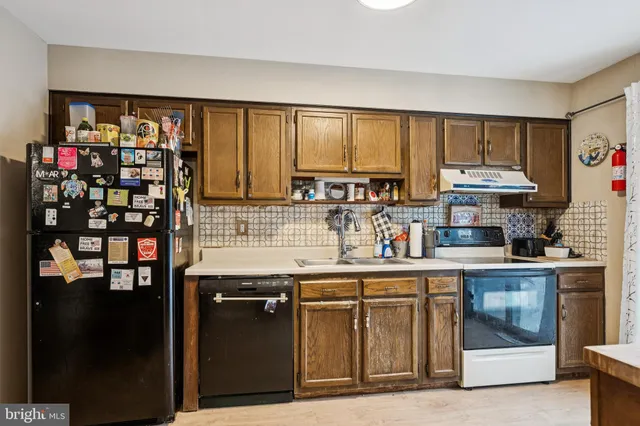 a kitchen with stainless steel appliances granite countertop a refrigerator and a stove top oven