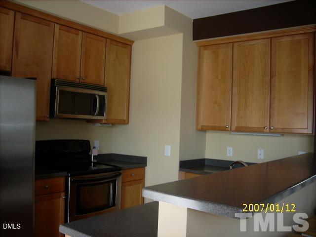 5109 Powell Townes Way Raleigh, NC 27606 - Photo 2 of 7 a kitchen with stainless steel appliances granite countertop a stove a microwave a sink and cabinets