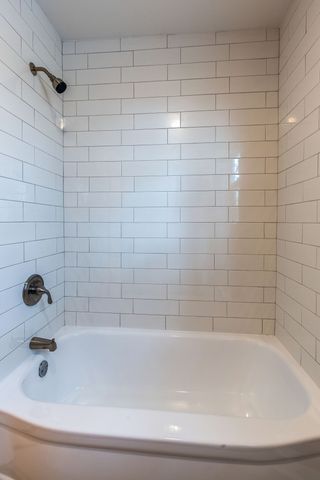 an empty room with wooden floor chandelier fan and windows