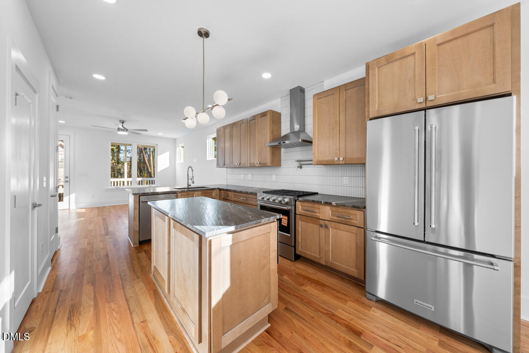 2530 West Wilson Street Durham, NC 27705 - Photo 13 of 49 a kitchen with kitchen island wooden floors appliances and cabinets