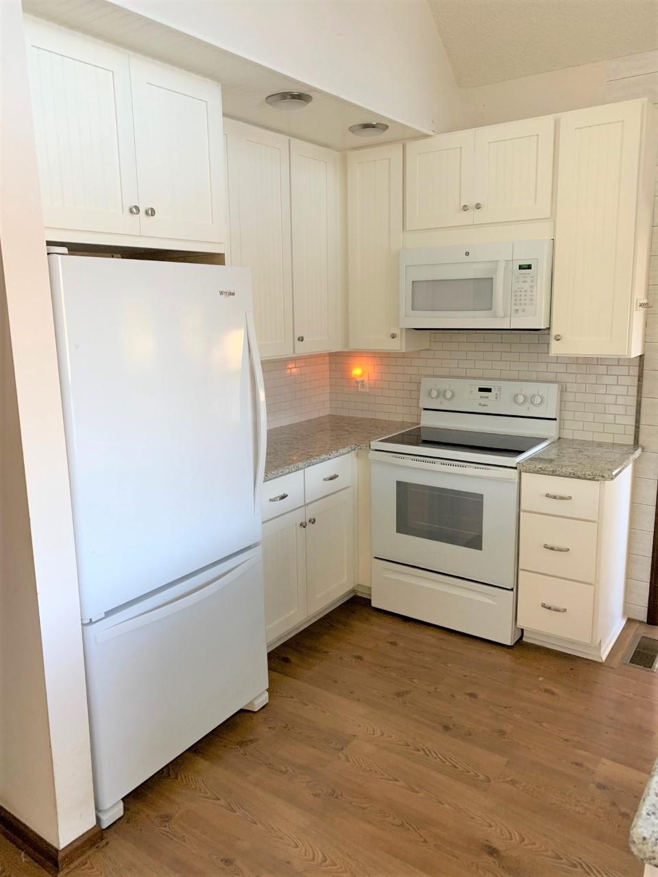 741 Lake Logan Road Ardmore, TN 38449 - Photo 8 of 13 a kitchen with cabinets stainless steel appliances and wooden floor