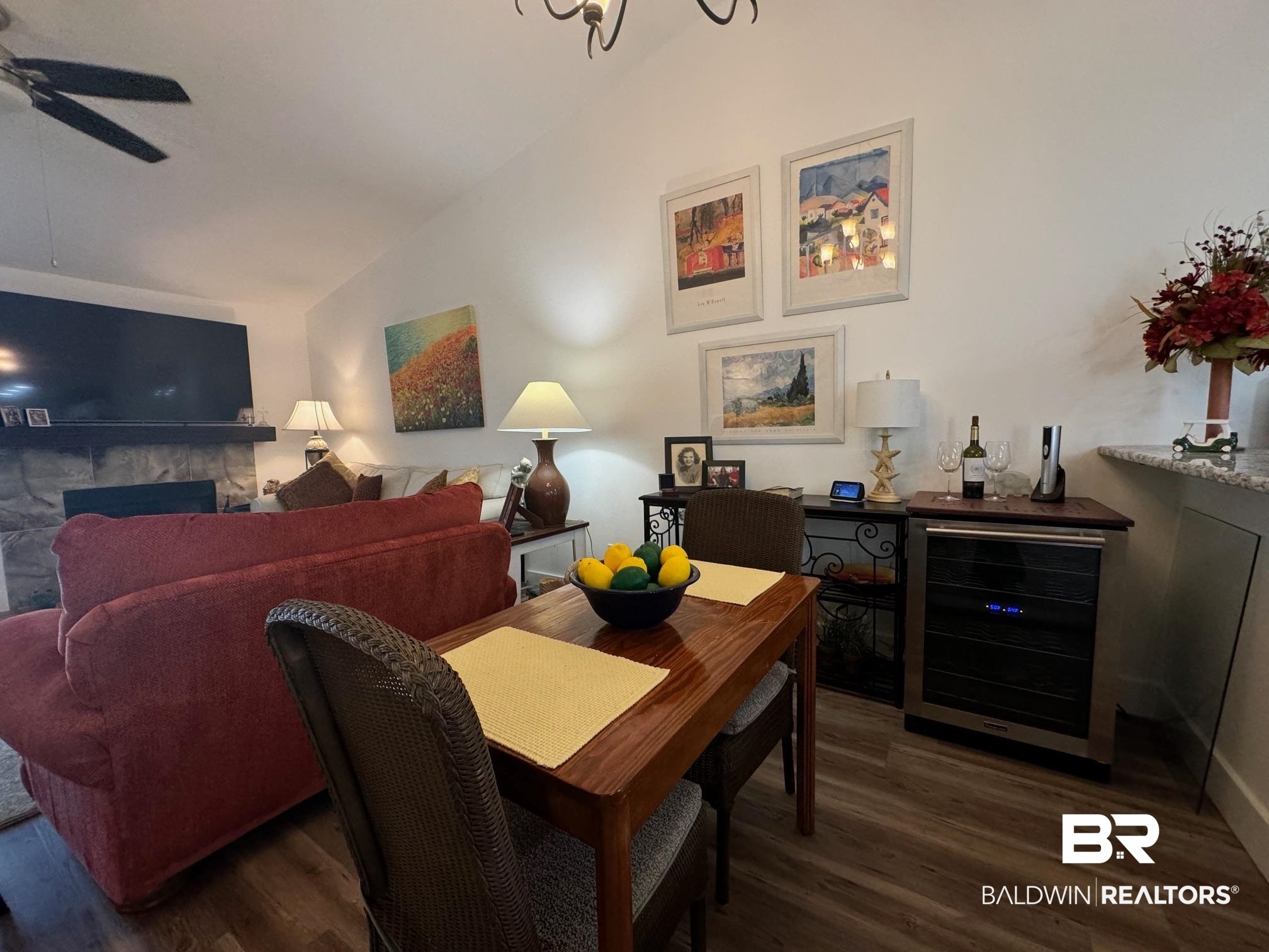 3200 Loop Road, Unit 55 Orange Beach, AL 36561 - Photo 6 of 40 Dining space featuring ceiling fan, beverage cooler, dark wood-type flooring, lofted ceiling, and a fireplace