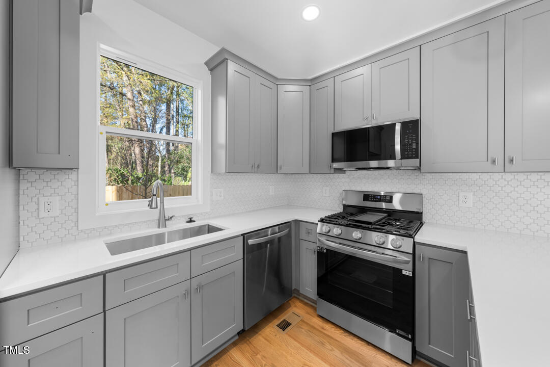 2503 Lednum Street Durham, NC 27704 - Photo 11 of 25 a kitchen with a sink stove top oven and cabinets