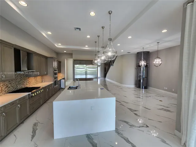 a kitchen with granite countertop a stove microwave and sink