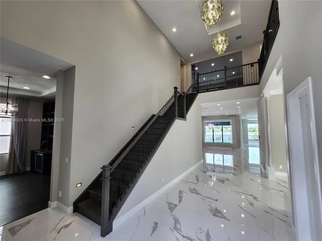 a view of a hallway with entryway windows chandelier and front door