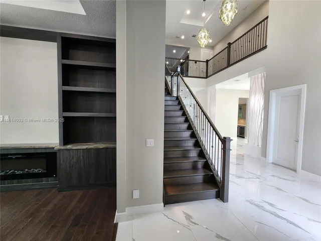 a large kitchen with stainless steel appliances a large counter top a stove and a sink