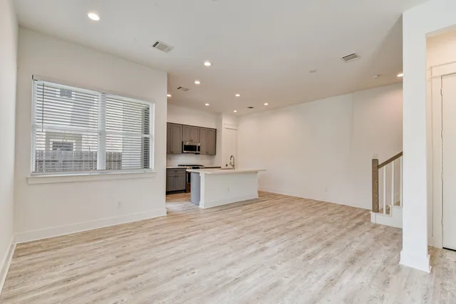a view of kitchen with stainless steel appliances kitchen island wooden floor and window