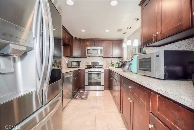 a kitchen with stainless steel appliances granite countertop a sink stove and microwave
