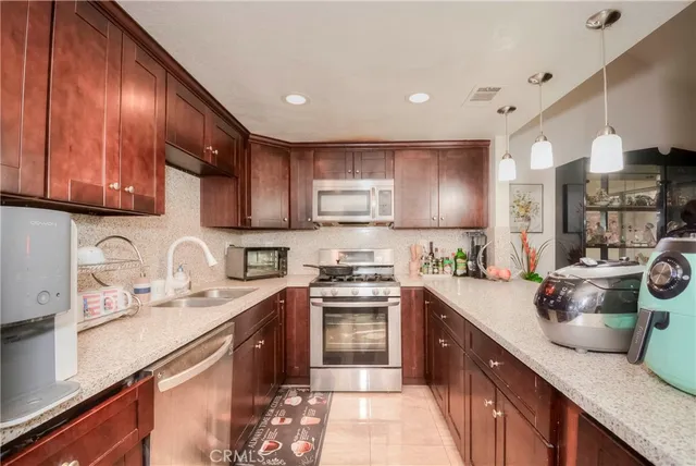 a kitchen with stainless steel appliances granite countertop a stove a sink a refrigerator and a microwave