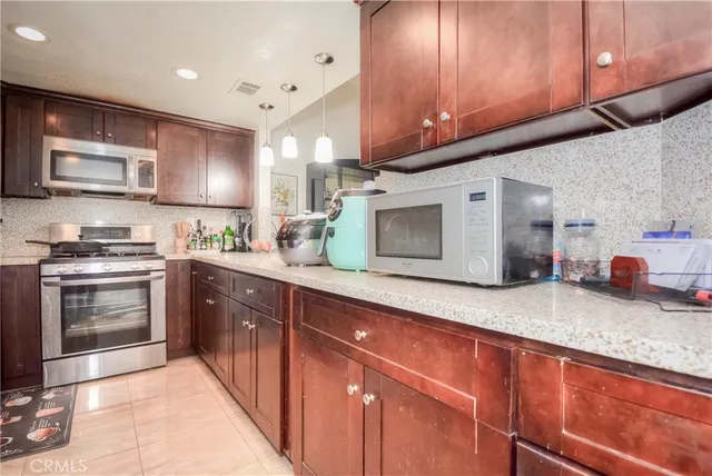 a kitchen with stainless steel appliances granite countertop a sink a stove and a wooden floors