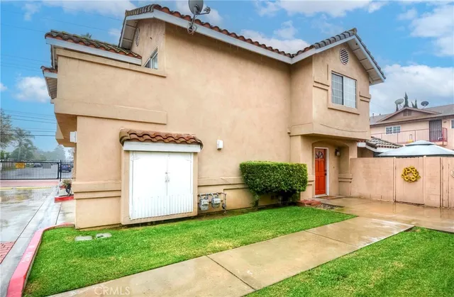 a view of a white house next to a yard