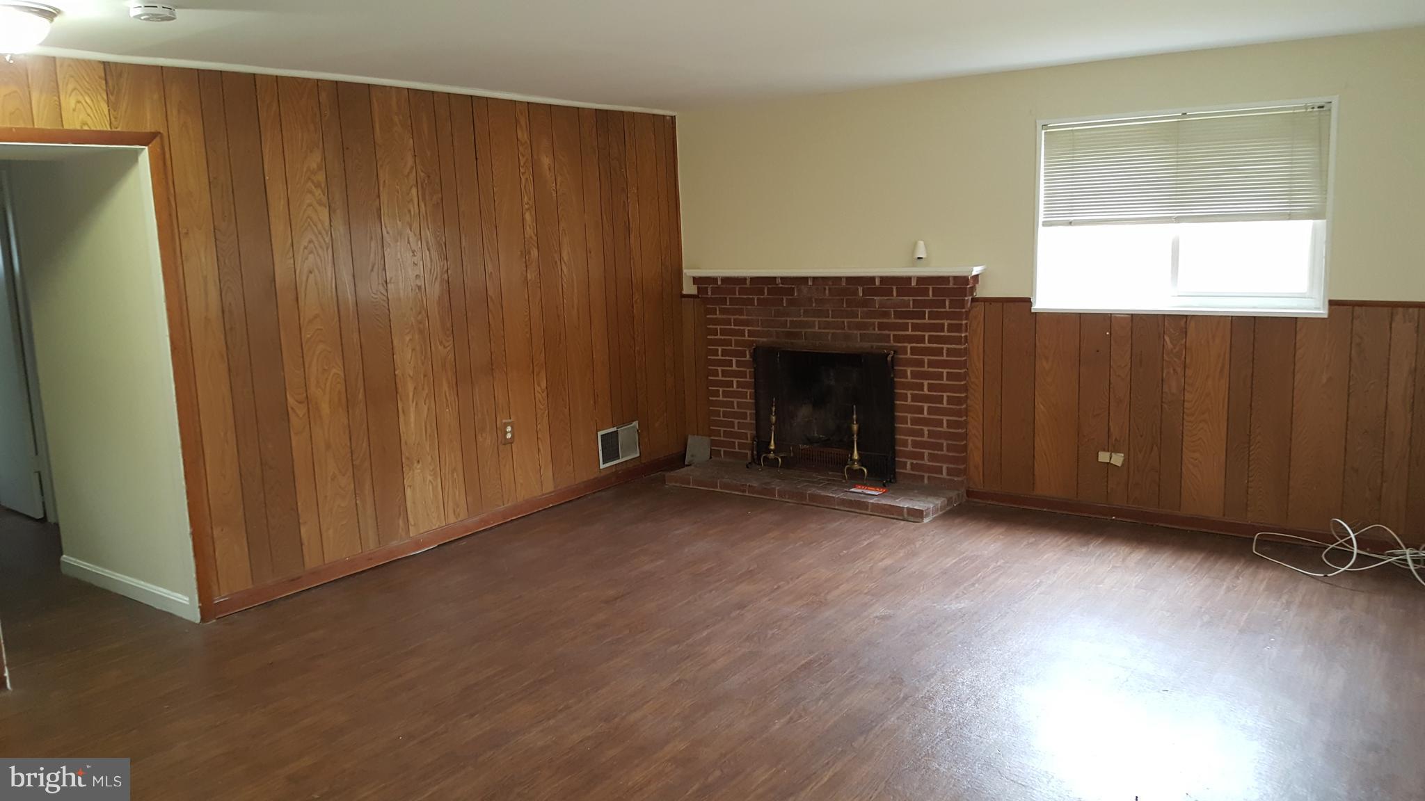 13112 Holdridge Road Silver Spring, MD 20906 - Photo 4 of 5 an empty room with windows fireplace and windows
