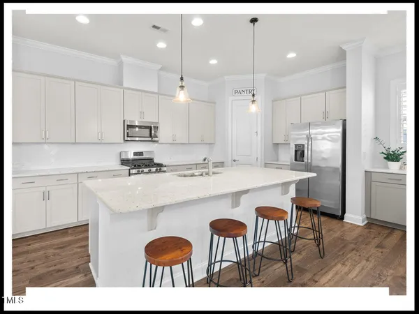 a dining hall with stainless steel appliances kitchen island granite countertop a dining table chairs and view living room