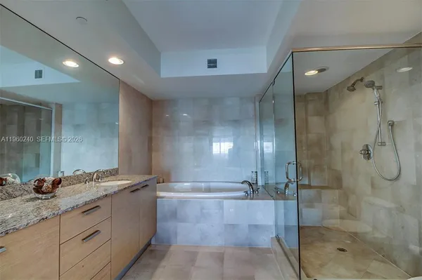 a bathroom with a granite countertop sink mirror and shower