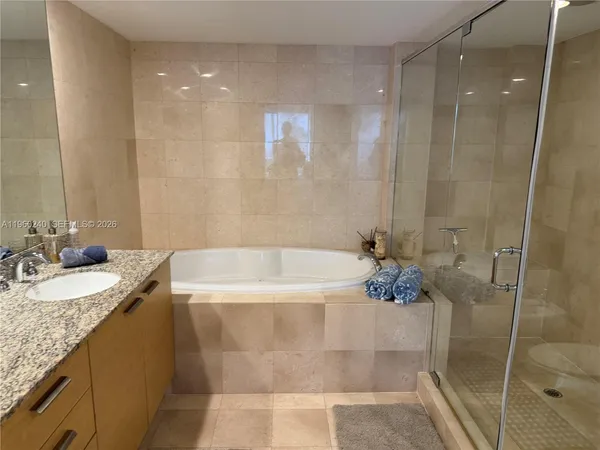 a bathroom with a granite countertop sink a shower and a mirror