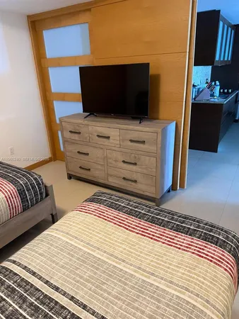 a bedroom with a bed and flat screen tv