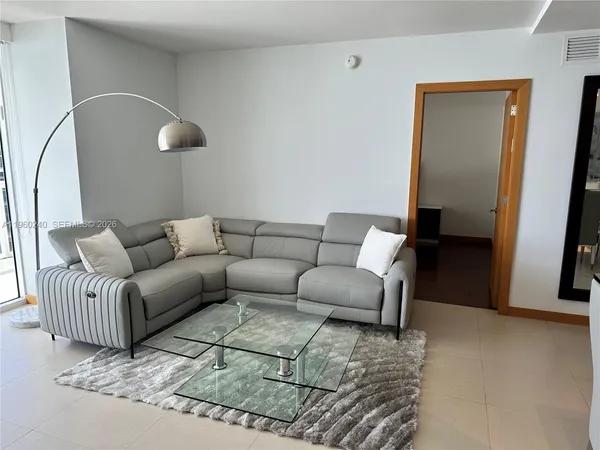 a living room with furniture and a mirror