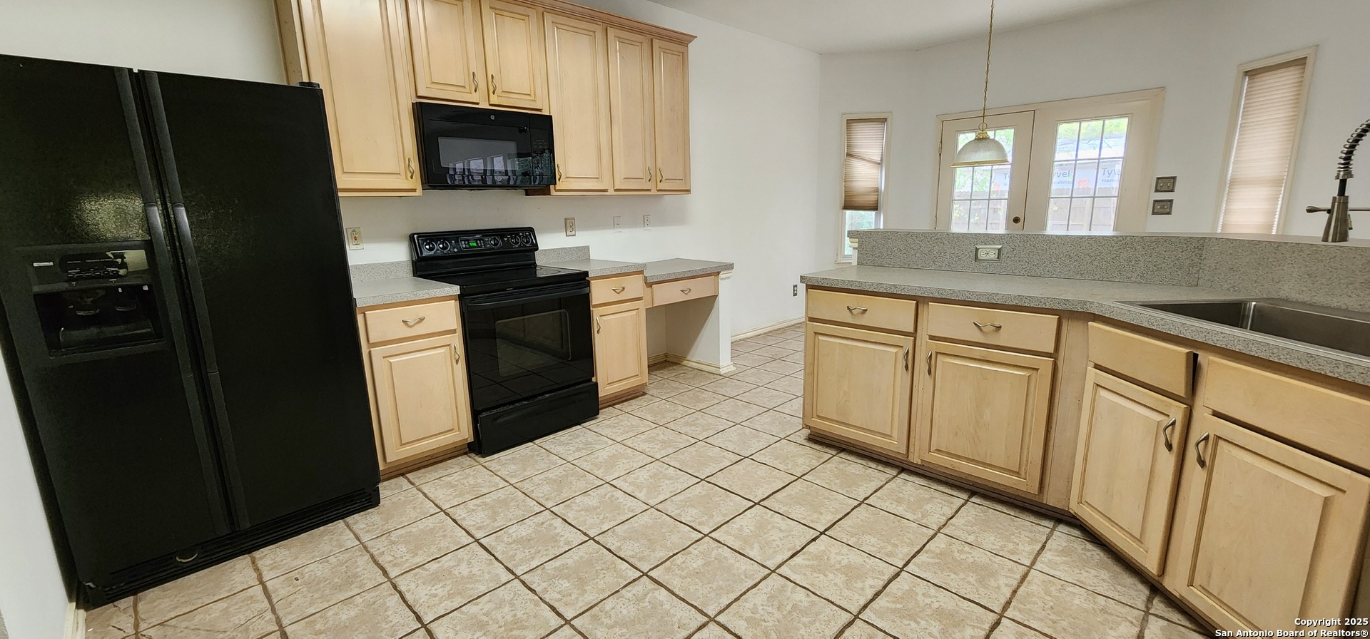 9318 Grand Cedar Helotes, TX 78023 - Photo 13 of 32 a kitchen with white cabinets a refrigerator and a sink
