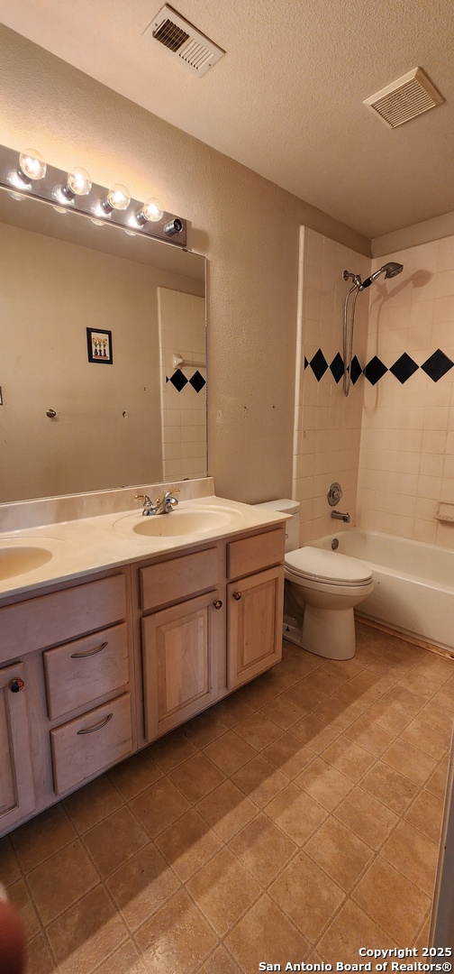 9318 Grand Cedar Helotes, TX 78023 - Photo 27 of 32 a bathroom with a double vanity sink mirror and toilet