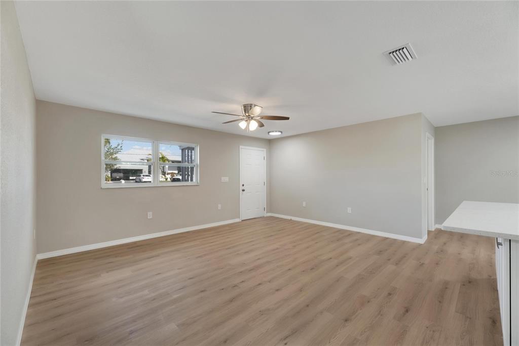 660 Flamingo Drive Apollo Beach, FL 33572 - Photo 12 of 63 an empty room with wooden floor chandelier fan and windows
