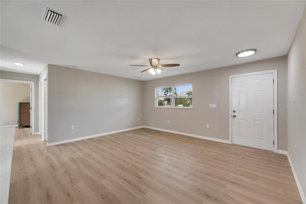 660 Flamingo Drive Apollo Beach, FL 33572 - Photo 13 of 63 an empty room with wooden floor and windows