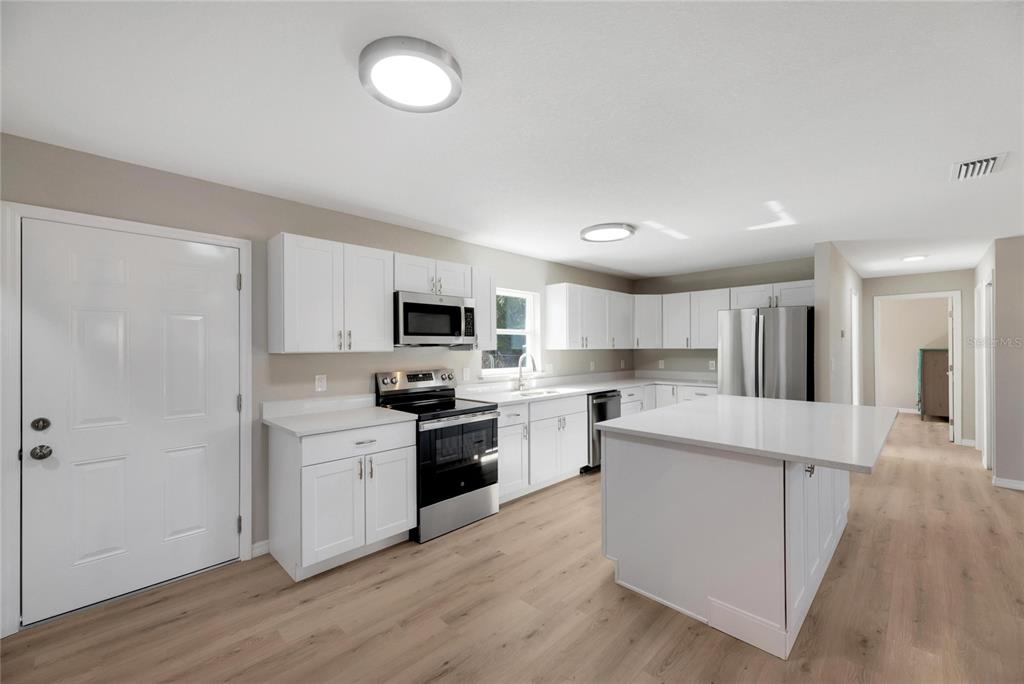 660 Flamingo Drive Apollo Beach, FL 33572 - Photo 18 of 63 a kitchen with white cabinets and stainless steel appliances