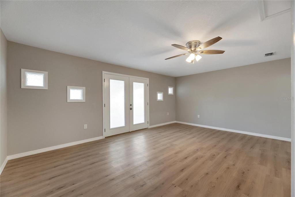 660 Flamingo Drive Apollo Beach, FL 33572 - Photo 3 of 63 a view of an empty room with chandelier fan and wooden floor