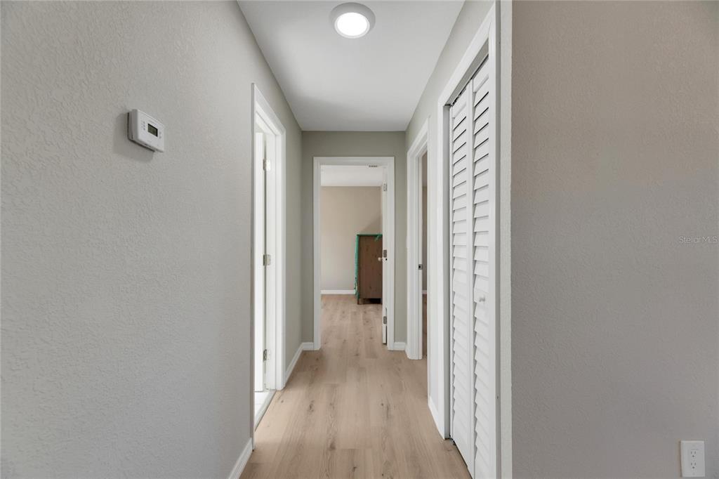 660 Flamingo Drive Apollo Beach, FL 33572 - Photo 32 of 63 a view of a hallway with wooden floor and a bathroom