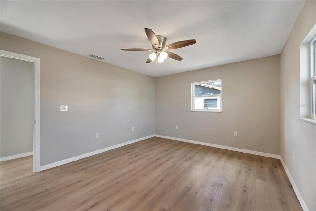 660 Flamingo Drive Apollo Beach, FL 33572 - Photo 34 of 63 an empty room with wooden floor ceiling fan and window