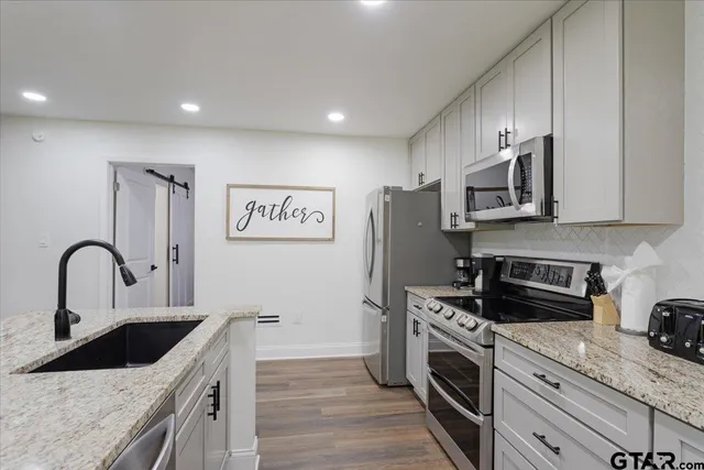 a kitchen with stainless steel appliances granite countertop a sink stove and refrigerator