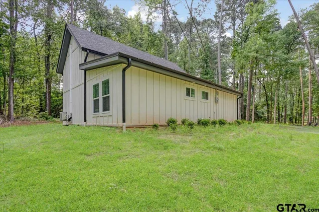 a view of a backyard with barn and wooden fence