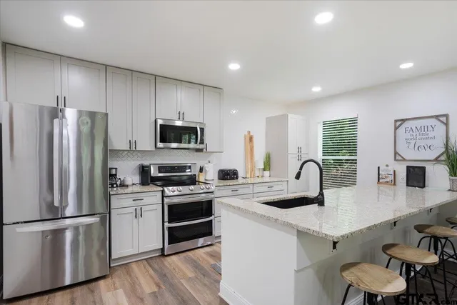 a kitchen with kitchen island a white counter top space cabinets and stainless steel appliances