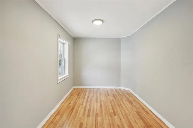a view of a bedroom with wooden floor and windows