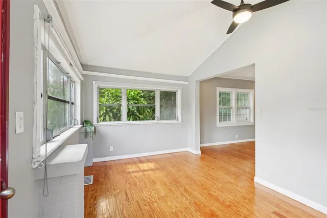 a view of a room with wooden floor and windows