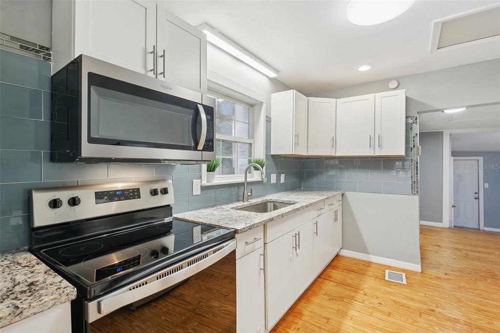 924 Vistabula Street Lakeland, FL 33801 - Photo 18 of 53 a kitchen with stainless steel appliances white cabinets and a stove top oven