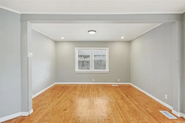 a view of a big room with wooden floor and windows