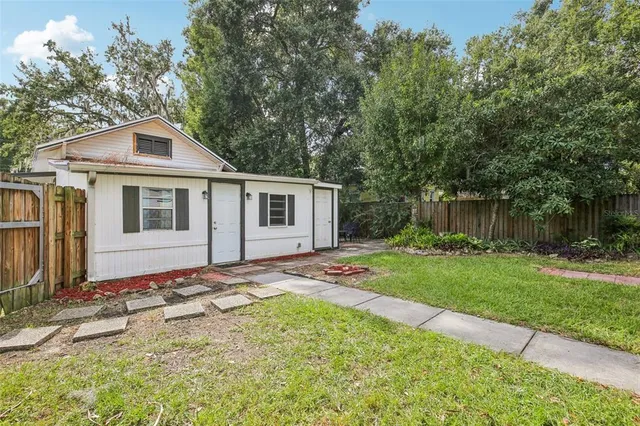 a view of a house with backyard and tree