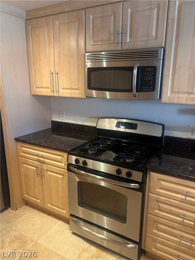 210 East Flamingo Road, Unit 123 Las Vegas, NV 89169 - Photo 6 of 17 Polished stone countertops complement natural wood cabinetry in this functional cooking space.