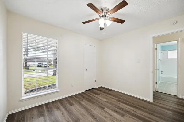 an empty room with wooden floor and windows