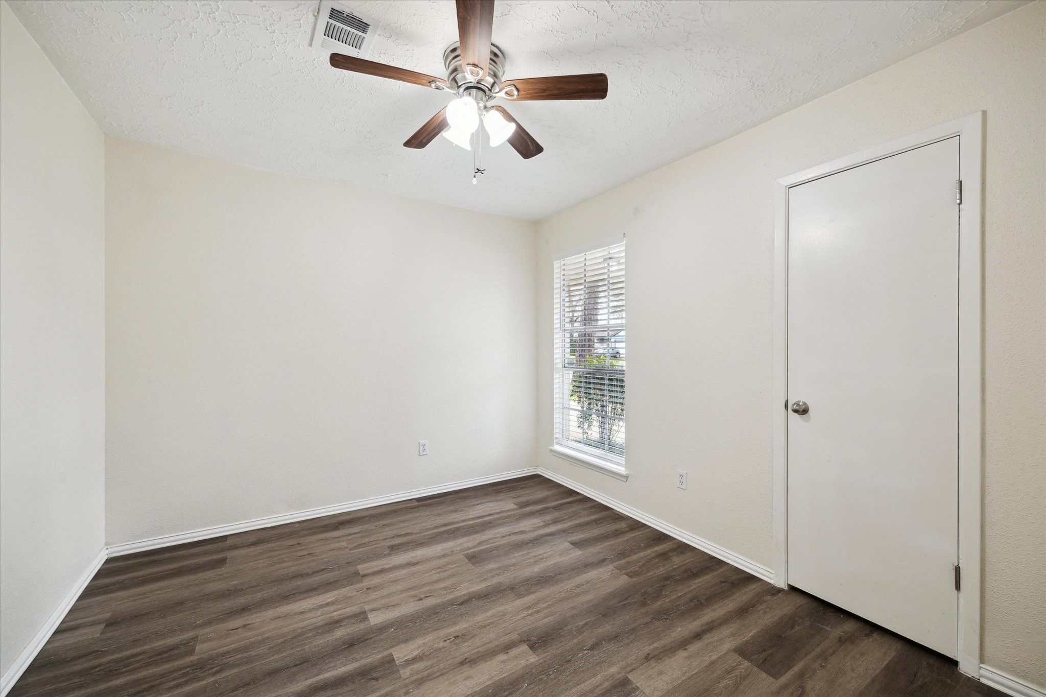 5815 Bridgegate Drive Spring, TX 77373 - Photo 15 of 17 an empty room with wooden floor fan and windows