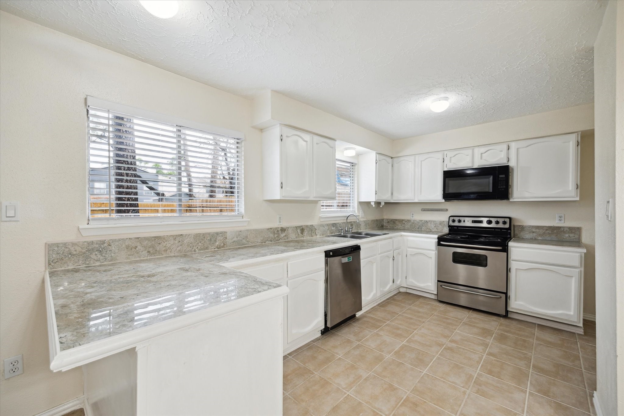 5815 Bridgegate Drive Spring, TX 77373 - Photo 5 of 17 a kitchen with a stove a sink and a microwave