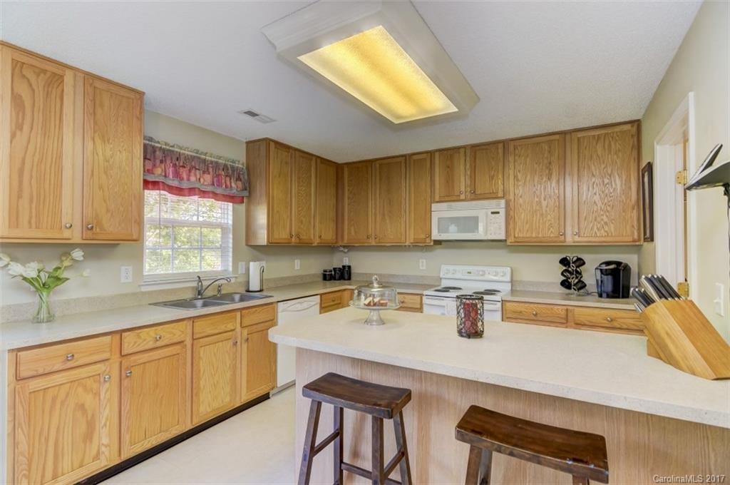 7467 Fallen Timber Lane, Unit 27 Tega Cay, SC 29708 - Photo 17 of 24 a kitchen with a sink a stove cabinets and counter space