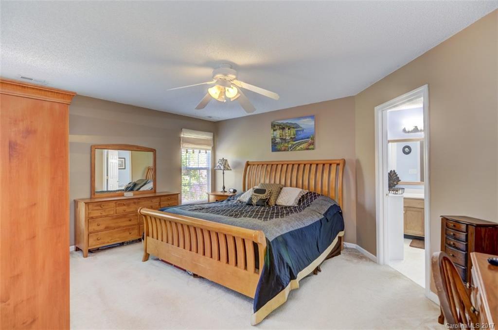 7467 Fallen Timber Lane, Unit 27 Tega Cay, SC 29708 - Photo 18 of 24 a bedroom with a bed and a chandelier
