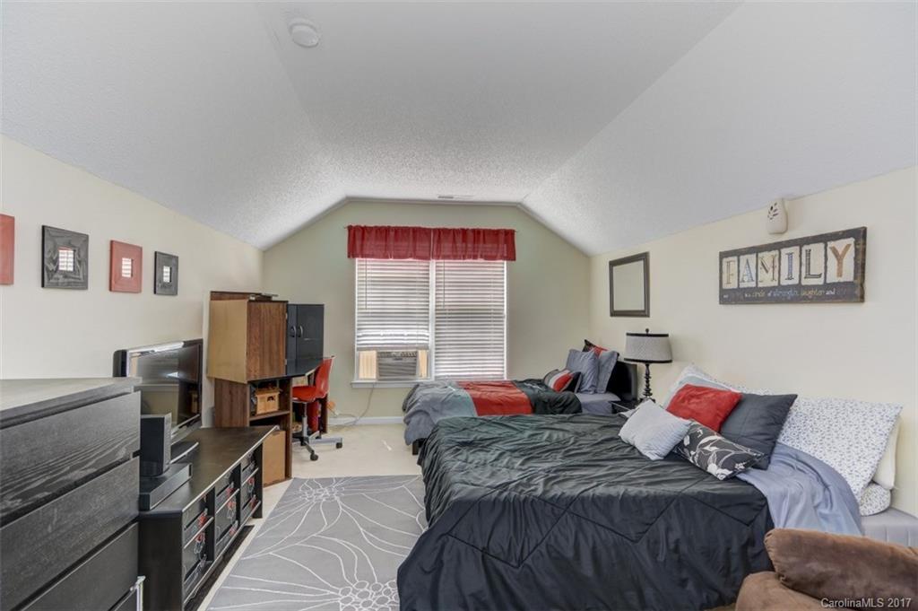 7467 Fallen Timber Lane, Unit 27 Tega Cay, SC 29708 - Photo 23 of 24 a bed room with a bed and dresser