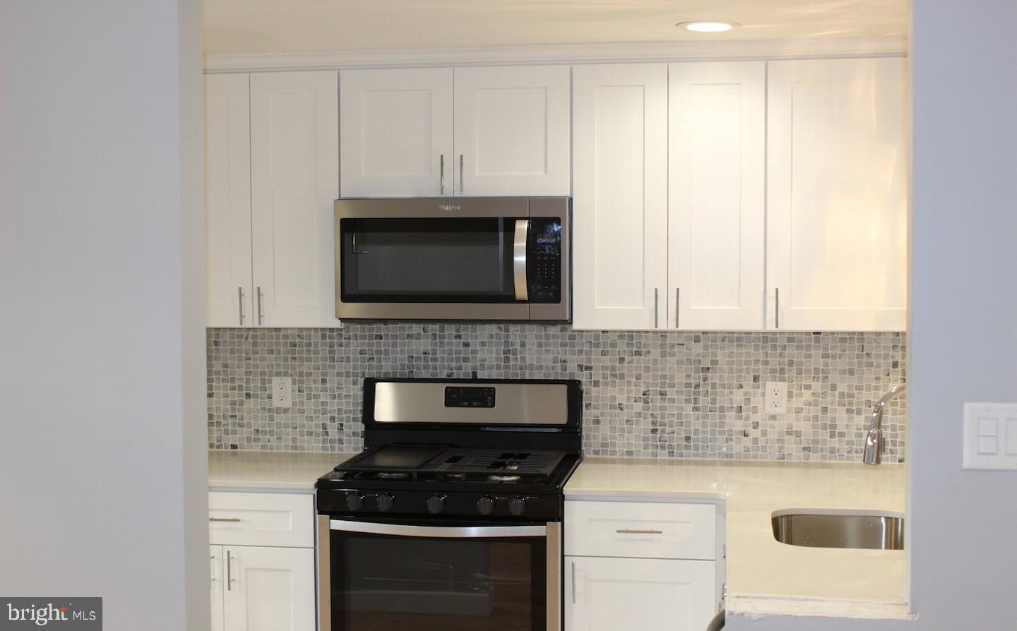 1244 Elson Road Brookhaven, PA 19015 - Photo 8 of 20 a kitchen with white cabinets and black appliances